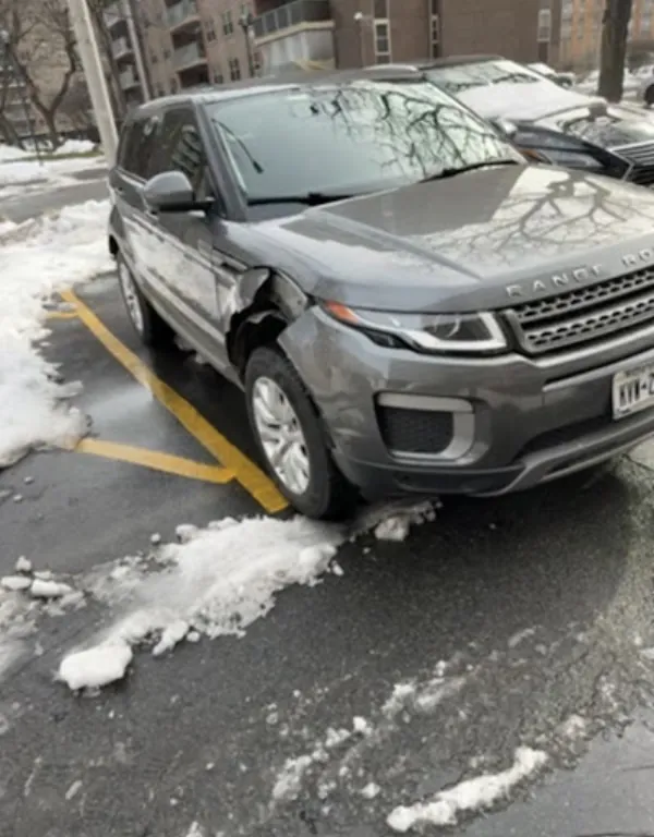 Grey Range Rover with a crushed front fender and bumper, before repair